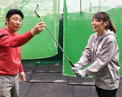 スイングの指導を受ける若い女性